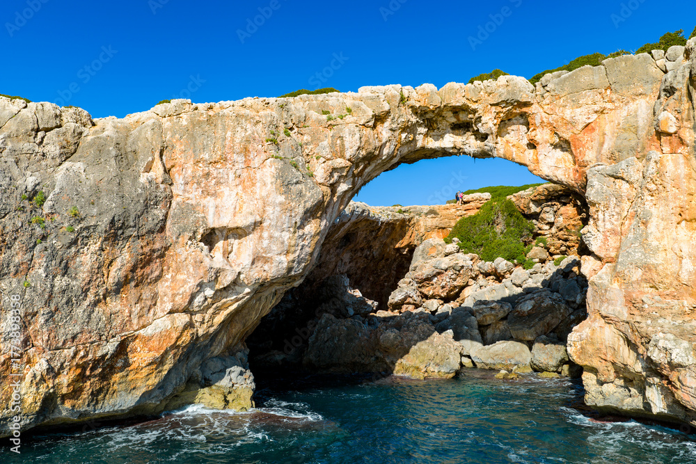 Fototapeta premium Aerial View: Cala Varques' Iconic Suspended Rock Arch Over the Mediterranean Sea, Mallorca