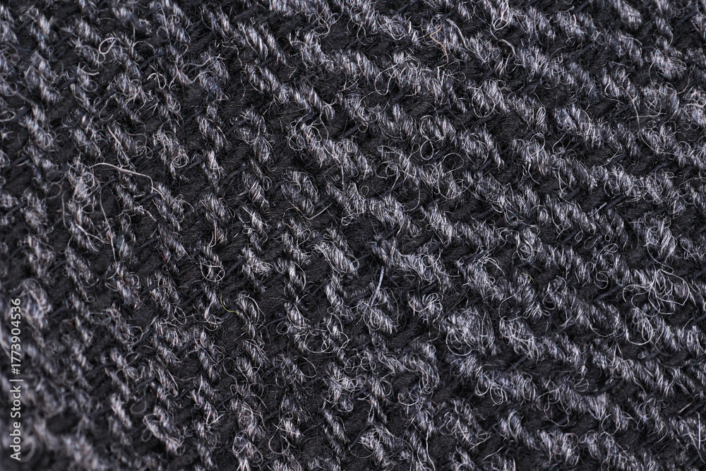 Fototapeta premium Extreme close-up macro shot of dark gray English tweed wool fabric. Shows the classic herringbone weave texture, natural fibers, and soft, durable textile material. Ideal for fashion and tailoring.