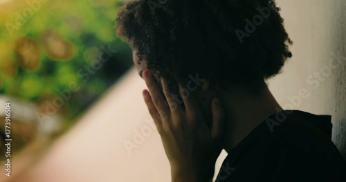 Wall Mural Young boy in emotional breakdown, hands covering face, standing against wall, Af