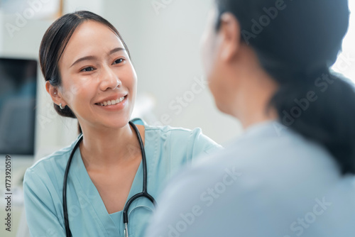Obraz na plátne Asian female doctor consults her senior patient with genuine care, while a compa