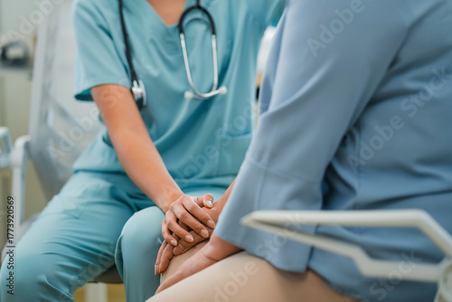 close-up shows a male professional doctor tenderly keeping a hand on a senior man's back in a hospital, compassionately showing care and support for the elderly patient's wellbeing
