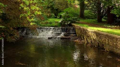 Water gently flowing down a waterfall in the Cotswolds. Cotswolds countryside, England