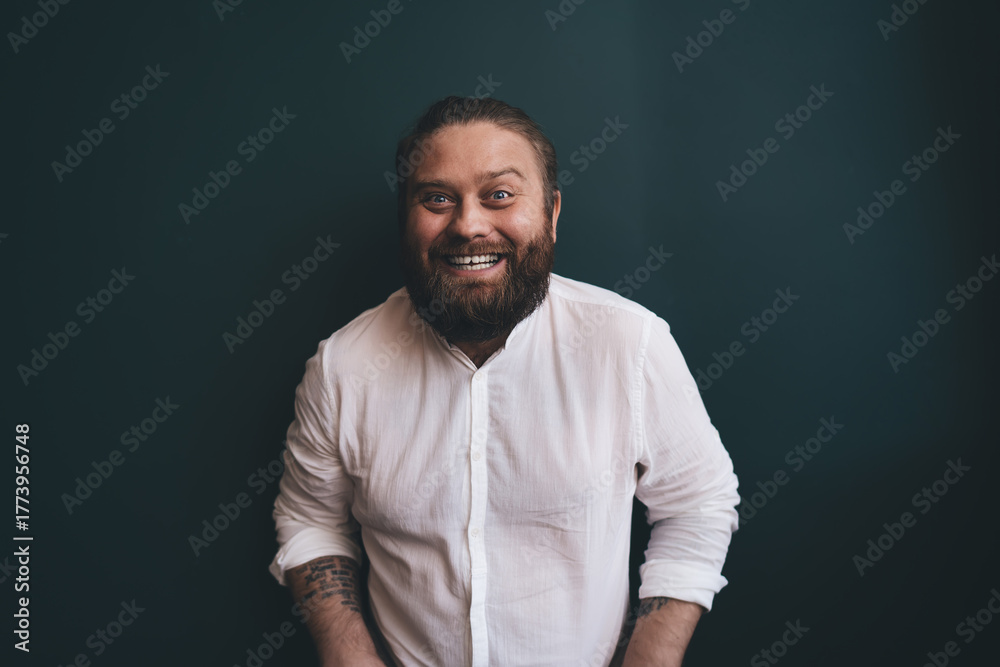 Fototapeta premium Bearded man smiling widely, leaning forward