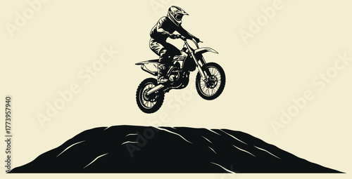 Silhouette of a motocross rider jumping high off a dirt hill against a neutral background