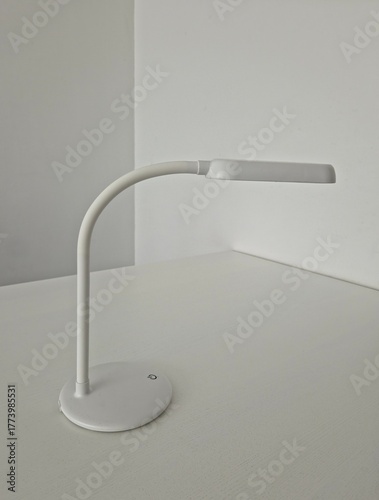 minimalistic white led lamp with button on the table