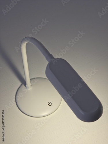 minimalistic white led lamp with button on the table