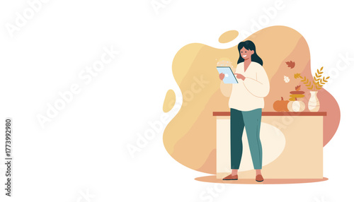 Happy woman using a digital tablet at home enjoying autumn seasonal decoration
