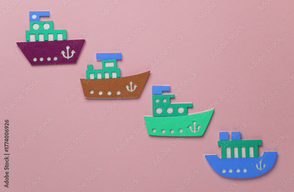 Obraz premium Toy ships made of felt on pink background. Travel concept