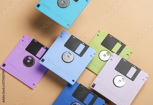 Floating colored retro 80s floppy disks on yellow background. Conceptual pop, creative layout