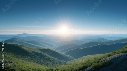 Panoramic view of sun rising over rolling mountains and green hills, concept of hope, freedom and natural beauty.