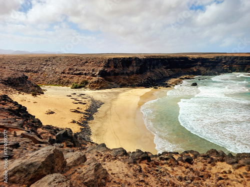 Cliffs on the beach. Extreme landscape of a cliffed coast, white sand beach, and blue sky. Coastal background.