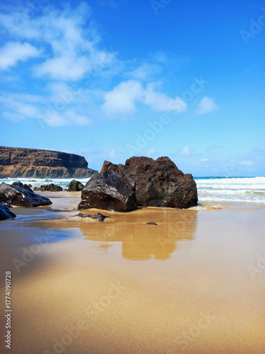 Cliffs on the beach. Extreme landscape of a cliffed coast, white sand beach, and blue sky. Coastal background.