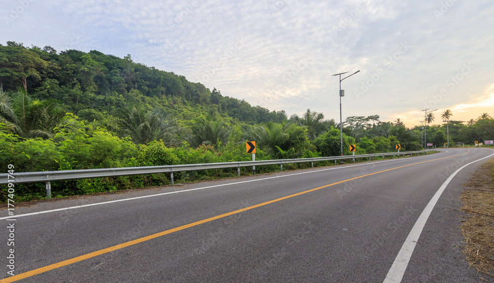 Fototapeta premium Road with a yellow line down the middle and a few trees in the background