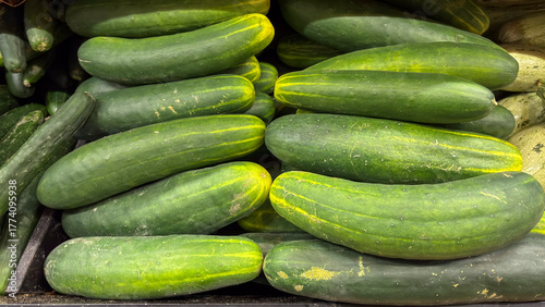 Foto Horizontal close-up of bulk cucumbers (Cucumis sativus) arranged for sale at a market or fair