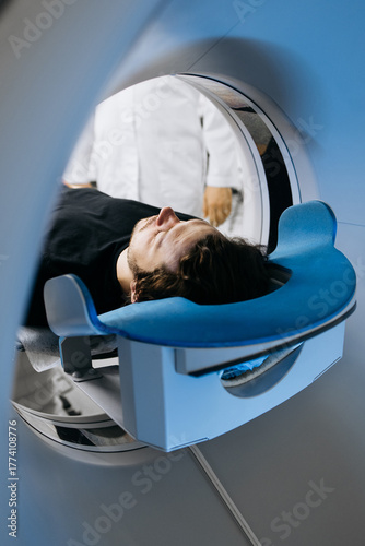 Patient lying on examination table inside a CT scanner, surrounded by medical professionals in white coats, showcasing advanced imaging technology and healthcare environment