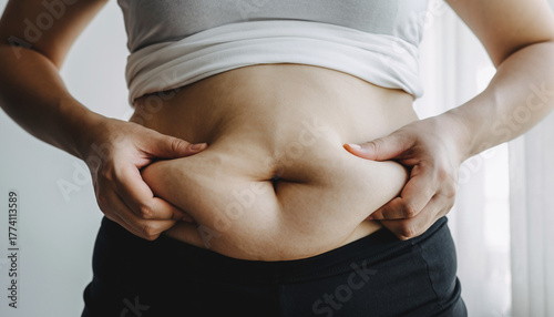 Close-up of a woman's midsection showing excess abdominal fat, illustrating weight gain and body image concerns