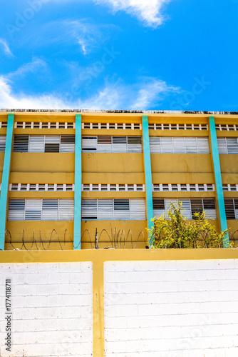 Pedernales, Dominican Republic, 8 august 2025. View of the facade of a typical Dominican school, paintend bright yellow against a blue sky.