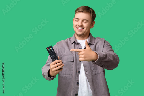 Young man pointing at TV re...