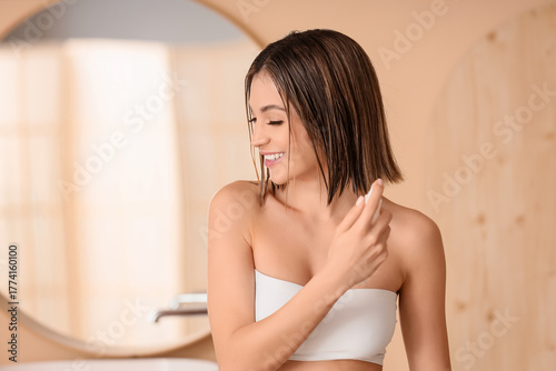 Happy young woman applying ...