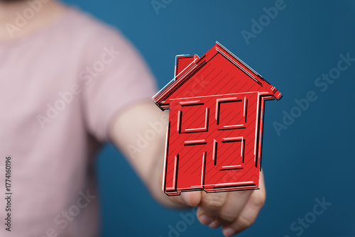 A person holding a red hous...