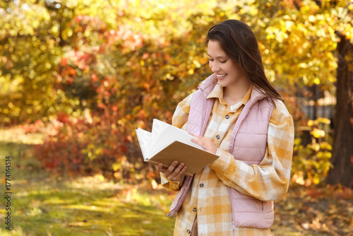 Happy young woman with book...
