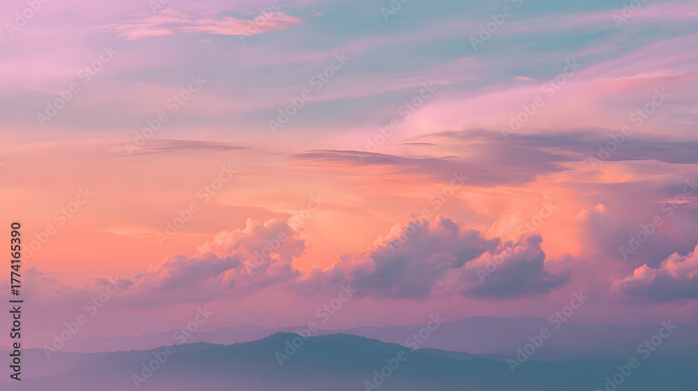 Obraz premium Vivid pastel clouds display intense coloration above layered mountain silhouettes at twilight