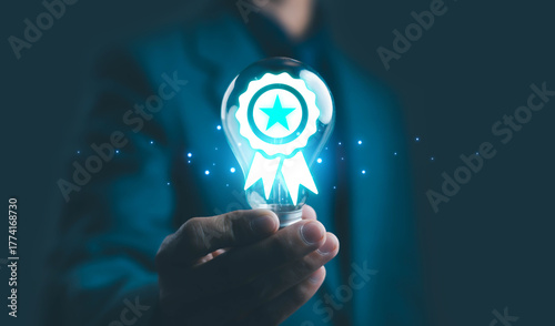Obraz na plátně Businessman holding glowing light bulb with award ribbon and star icon, representing innovation, quality achievement, creative excellence, and business success in modern technology concept