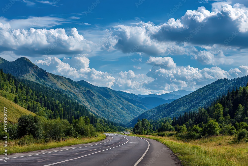 Fototapeta premium Scenic Valley Road with Lush Green Mountains and Blue Sky with Fluffy Clouds