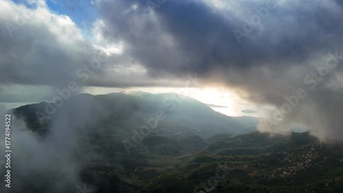 Aerial view of mountain village, coastline and islands through the morning clouds.