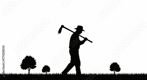 Silhouette of a farmer carrying a hoe over his shoulder walking through a field.