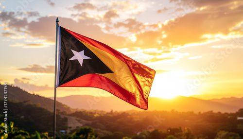 Stunning Timor Leste flag waves proudly against a vibrant golden sunset over rolling hills, symbolizing national pride and freedom.
