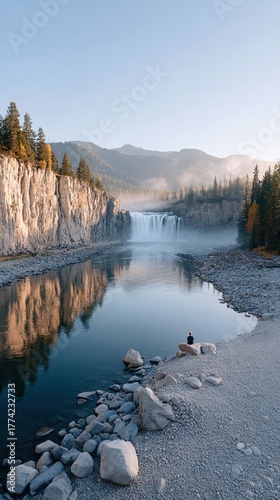 Serene Waterfall Landscape With A Lone Figure Meditating By The Water In Morning Light With Rocky Shoreline And Autumn Trees