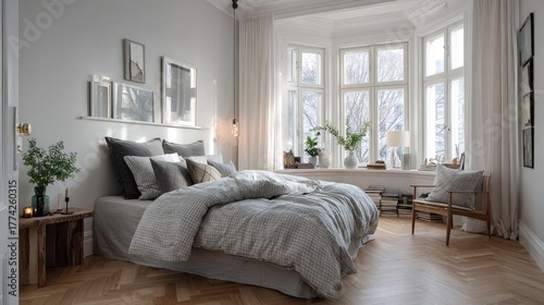Serene Nordic bedroom with gray bedding, white interior, herringbone parquet, and wide window lighting up the space