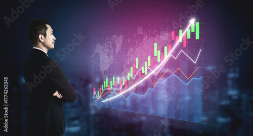 Fotografie A professional businessman stands in a modern office, observing dynamic stock market trends displayed on a digital screen, symbolizing financial success