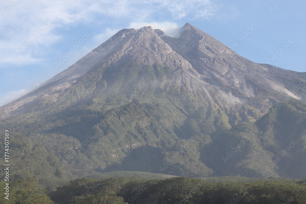 Fototapeta premium Active Volcanic Peak Surrounded by Green Forest and Exposed Rock Slopes