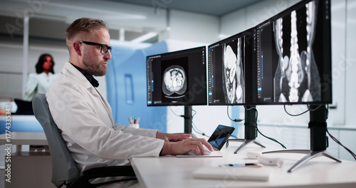 Skilled Surgeon Examines Lumbar MRI On Desktop Computer
