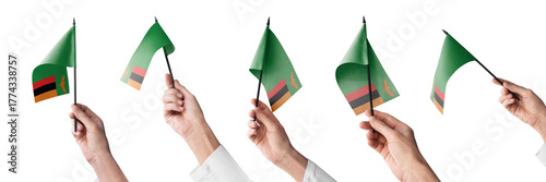 The Zambia flag in hand in different angles on a white background