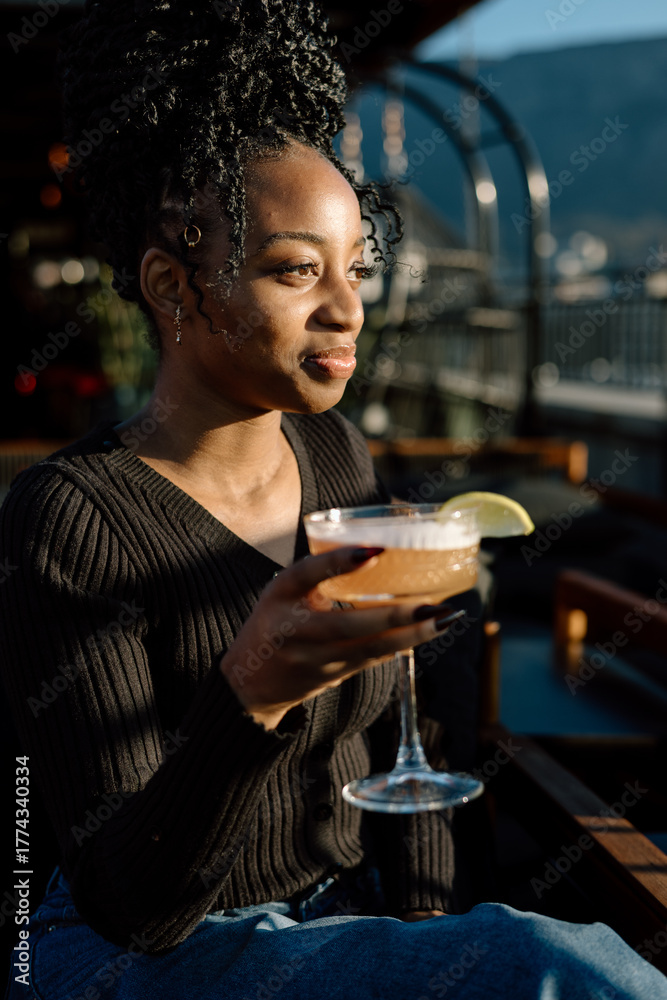 Fototapeta premium Women drinking a cocktail in an outdoor bar