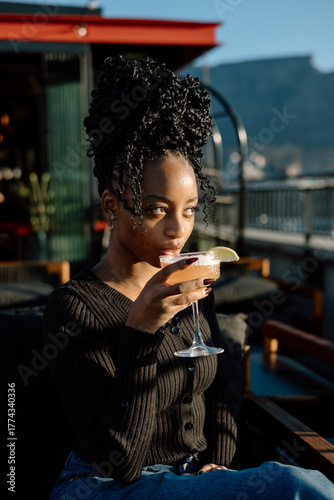 Young woman drinking a cocktail outdoors