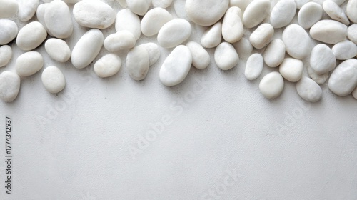 smooth white pebbles evenly spread on light gray surface, soft daylight, minimal spa composition background