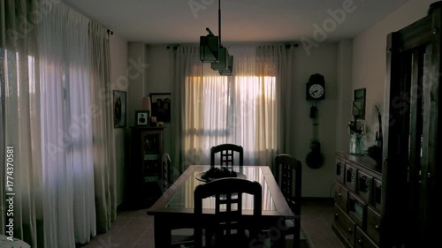 Time lapse of sunrise in dining room with wooden furniture and an antique clock