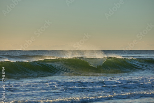 The blue to yellow hues of pre-dawn add emphasis to the breaking waves