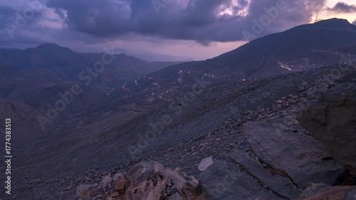 Time lapse of light car traffic moving at night on the road at Jable Jai, Ras Al Khaimah, United Arab Emirates.