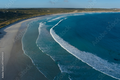 The waves in the clear blue waters calmly roll toward the shore