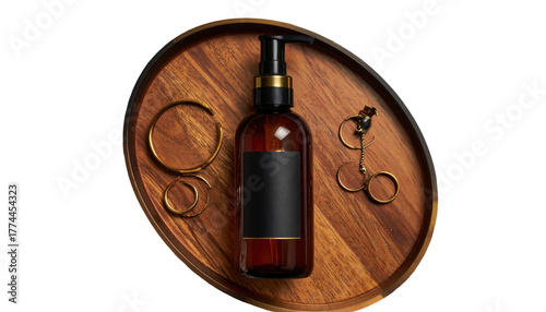 Overhead shot of a dark bottle, jewelry, on a wooden tray, against a black background