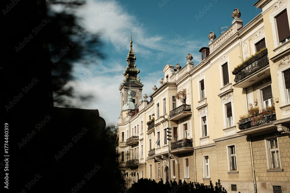 Obraz premium Historic architecture and church tower under blue autumn sky in Belgrade. Warm light and classic European charm