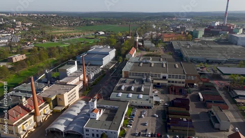 Sweeping Aerial Wide Shot of the Pilsner Urquell Industrial Brewery Complex in Pilsen, Czechia, Under a Clear Blue Spring Sky.