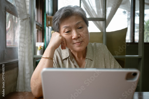 Free Download Asian Elderly Woman Actively Engaged using tablet, Various Online Activities from the Comfort of Her Home - GFXLoad