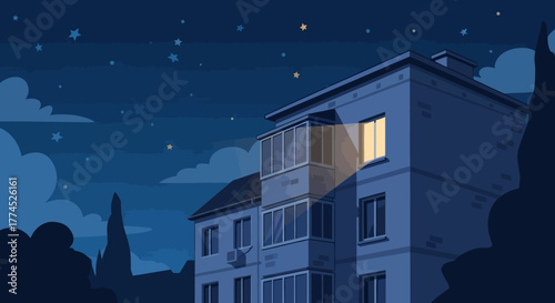 Apartment building with a single illuminated window at night.