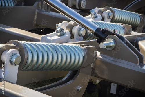 Steel spring as part of heavy agricultural, industrial machine. Technology